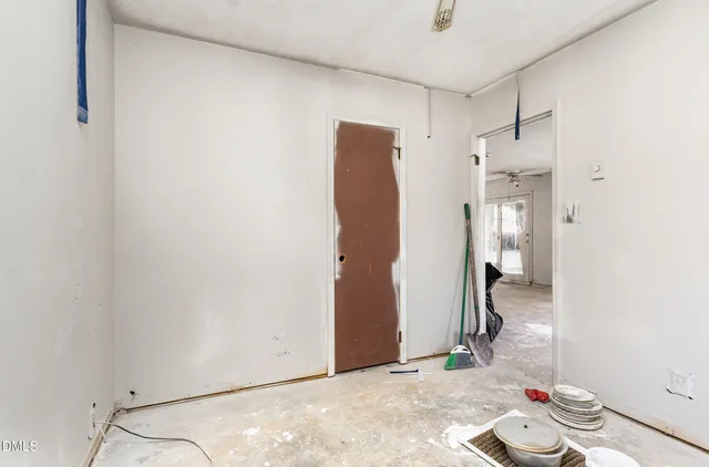 a view of a hallway with wooden floor and a bathroom