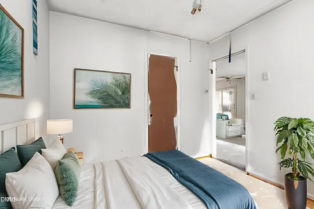 a bedroom with a bed and a potted plant