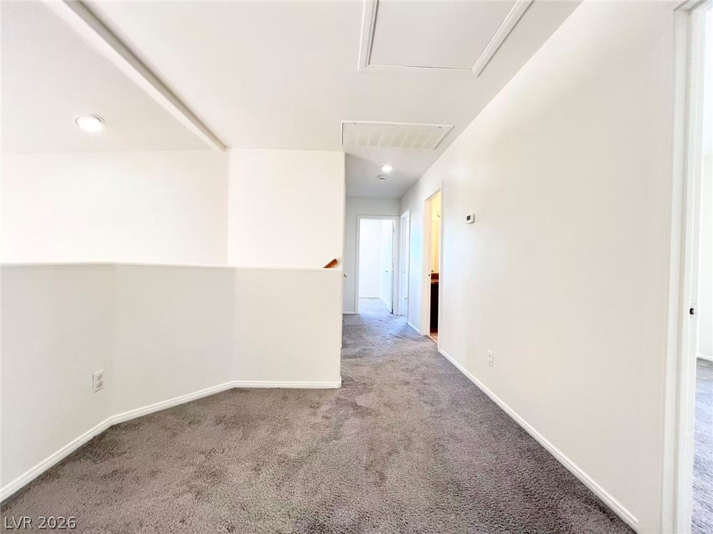 8284 West Rochelle Avenue Las Vegas, NV 89147 - Photo 18 of 29 An inviting hallway with plush gray carpet and bright recessed lighting.