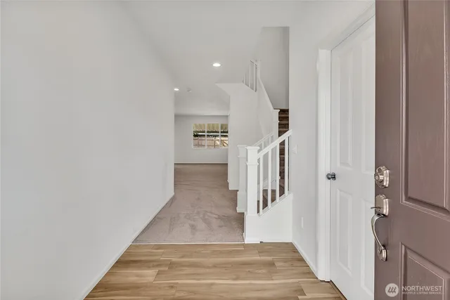 a view of a hallway with wooden floor and staircase