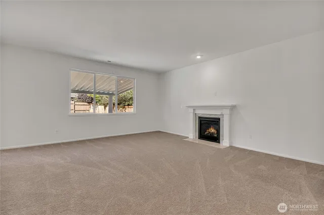 an empty room with windows and fireplace