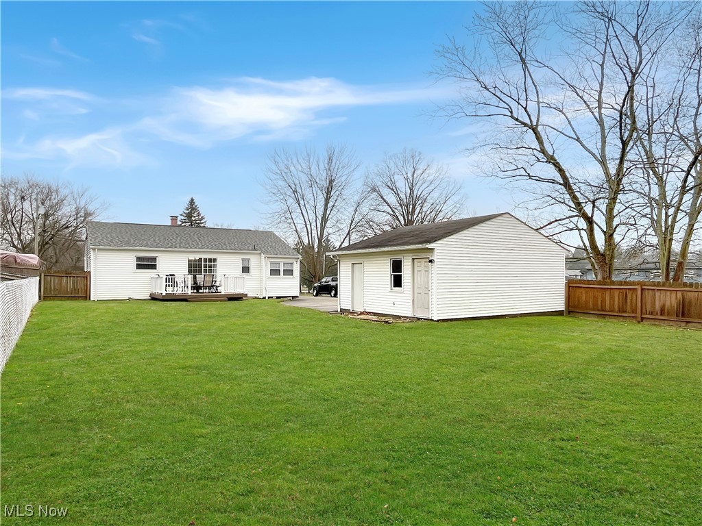 3968 Cannon Road Youngstown, OH 44515 - Photo 23 of 25 Back of property featuring a fenced backyard, an outbuilding, a wooden deck, and a chimney