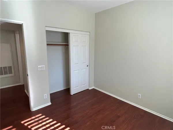 an empty room with wooden floor and closet