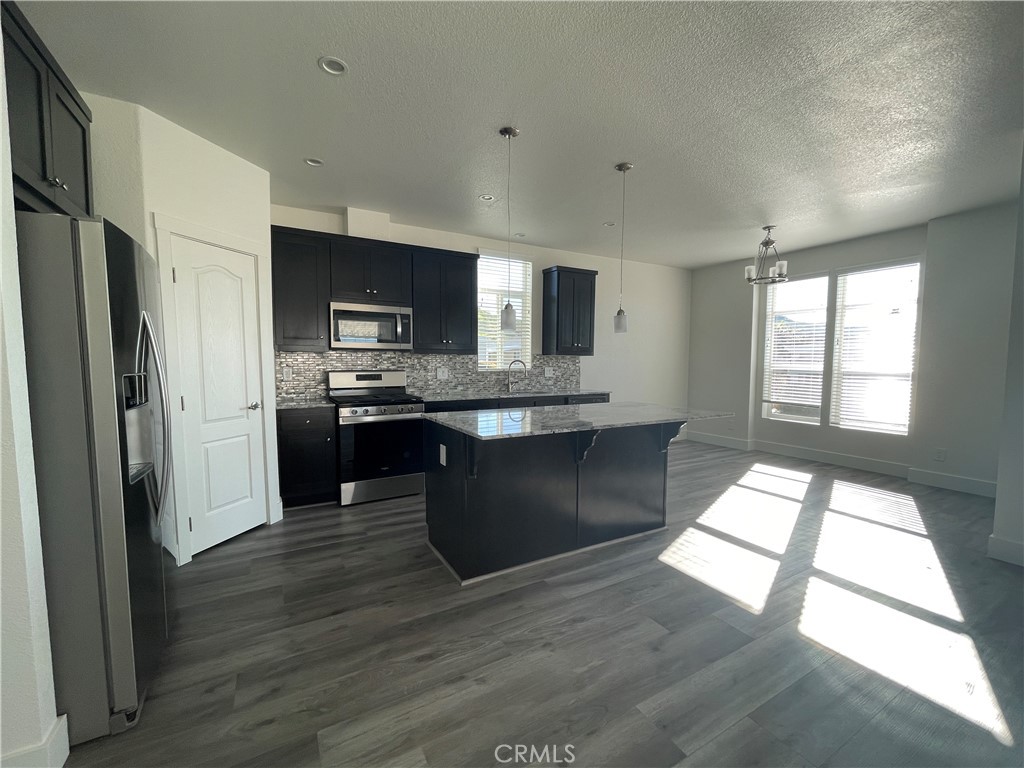 3500 Buchanan Street, Unit 138 Riverside, CA 92503 - Photo 3 of 18 a kitchen with stainless steel appliances granite countertop a refrigerator a sink a stove a microwave and wooden floor