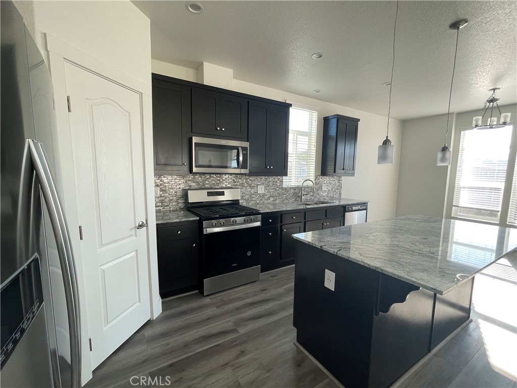 3500 Buchanan Street, Unit 138 Riverside, CA 92503 - Photo 4 of 18 a kitchen with stainless steel appliances granite countertop a refrigerator a sink dishwasher a stove and white countertops with wooden floor