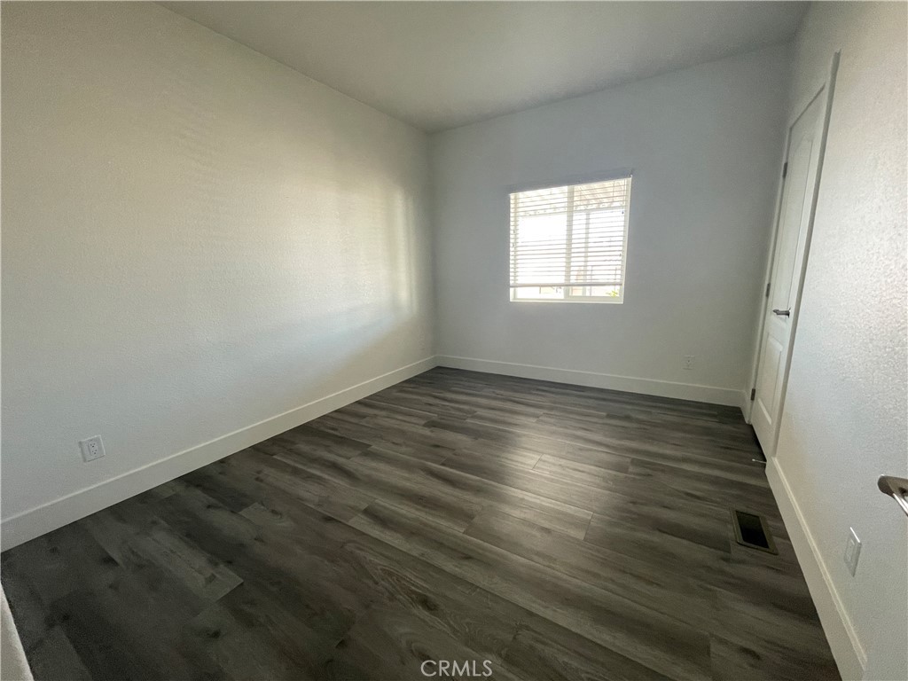 3500 Buchanan Street, Unit 138 Riverside, CA 92503 - Photo 6 of 18 an empty room with wooden floor and windows