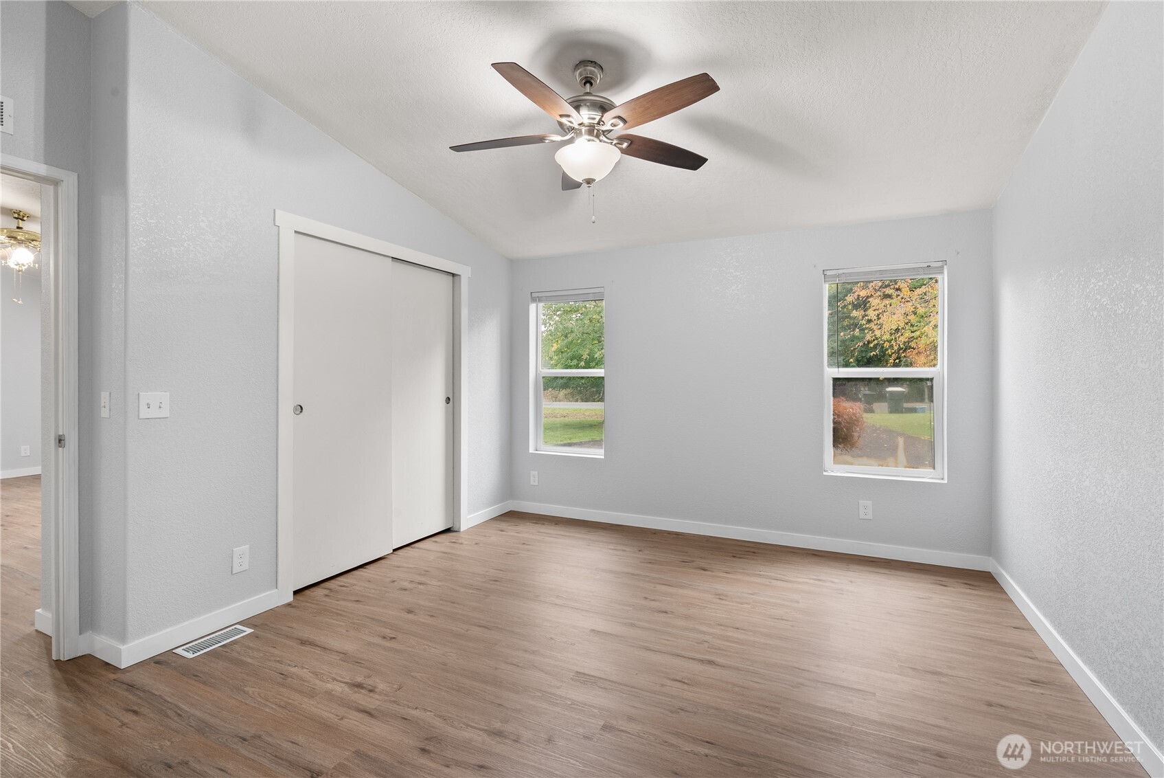 11727 Driver Street Southwest Olympia, WA 98512 - Photo 11 of 33 an empty room with wooden floor chandelier fan and windows