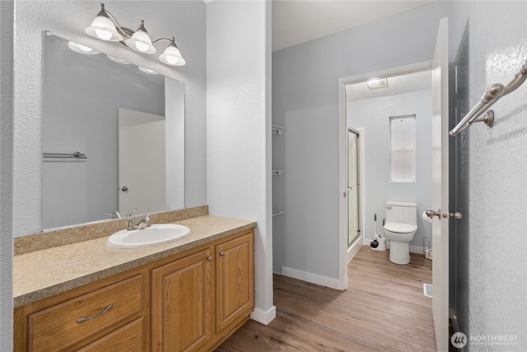 11727 Driver Street Southwest Olympia, WA 98512 - Photo 12 of 33 a bathroom with a granite countertop sink a toilet and a large mirror
