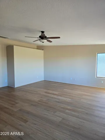 a view of wooden floor cabinets and a window in an empty room