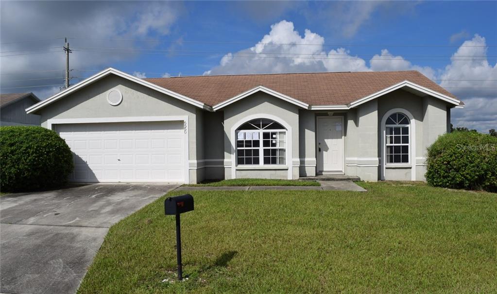 6550 Crews Vue Loop Lakeland, FL 33813 - Photo 1 of 1 a front view of a house with a yard and garage