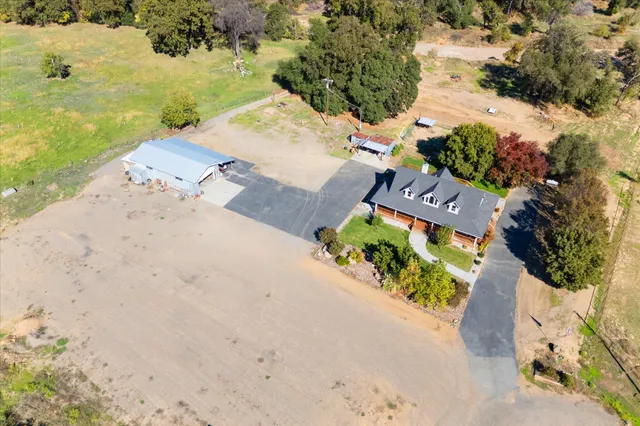 an aerial view of a house with a yard and lake view