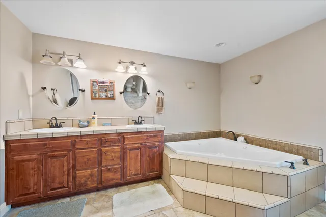 a spacious bathroom with a granite countertop sink and a mirror
