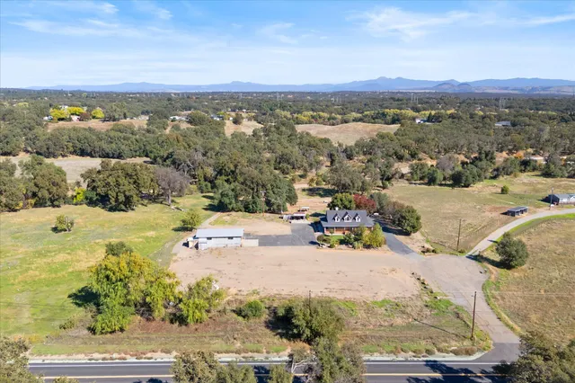 an aerial view of a house with a mountain