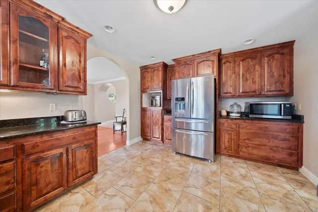 a kitchen with stainless steel appliances granite countertop a refrigerator stove top oven and a sink
