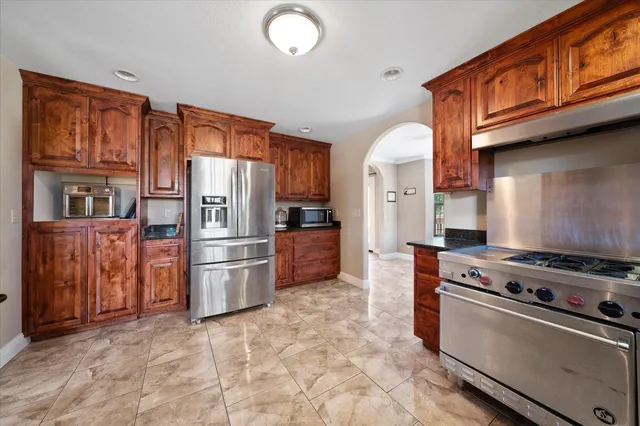 a kitchen with stainless steel appliances granite countertop a refrigerator stove and oven