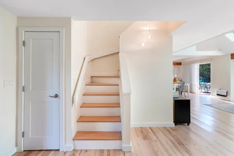 a view of a living room with wooden floor and staircase