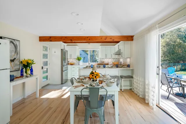 a very nice looking dining room with a large window and wooden floor