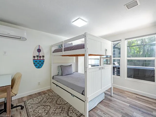 a view of a bedroom with furniture and window