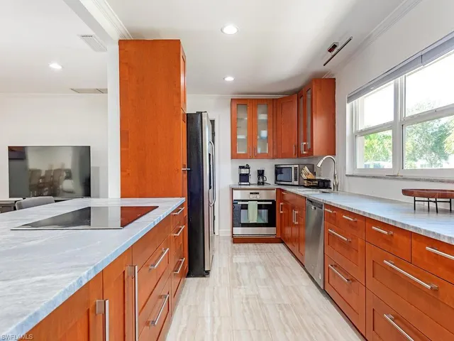 a kitchen with stainless steel appliances granite countertop sink stove refrigerator and cabinets
