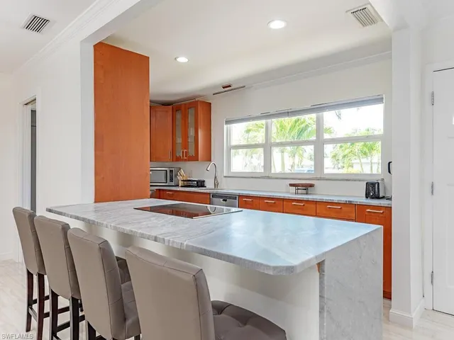 a kitchen with a table chairs sink and cabinets