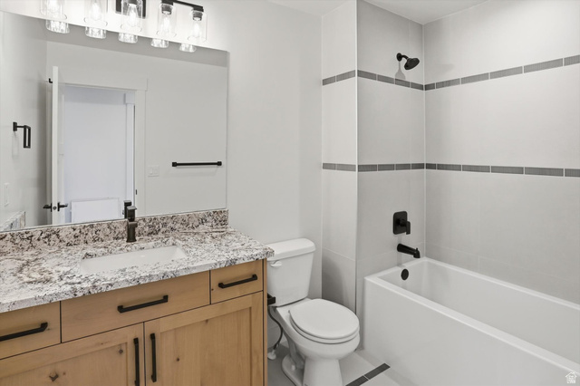 1315 West 3200 South, Unit 17 Perry, UT 84302 - Photo 40 of 58 Bathroom featuring a wood-tone vanity with a speckled countertop, an integrated sink, and a framed mirror