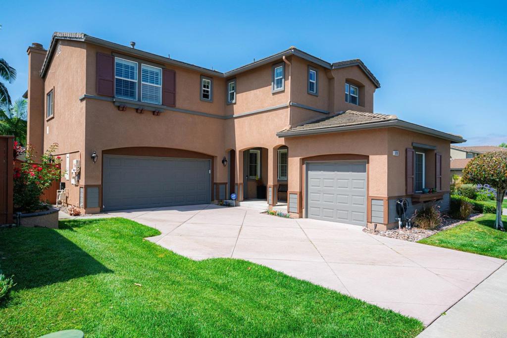 5191 Cobalt Way Oceanside, CA 92057 - Photo 1 of 61 a front view of a house with a yard and garage