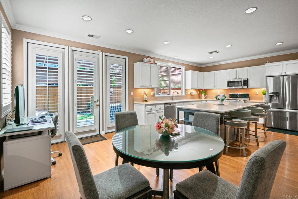 5191 Cobalt Way Oceanside, CA 92057 - Photo 17 of 61 a kitchen with a dining table chairs and refrigerator