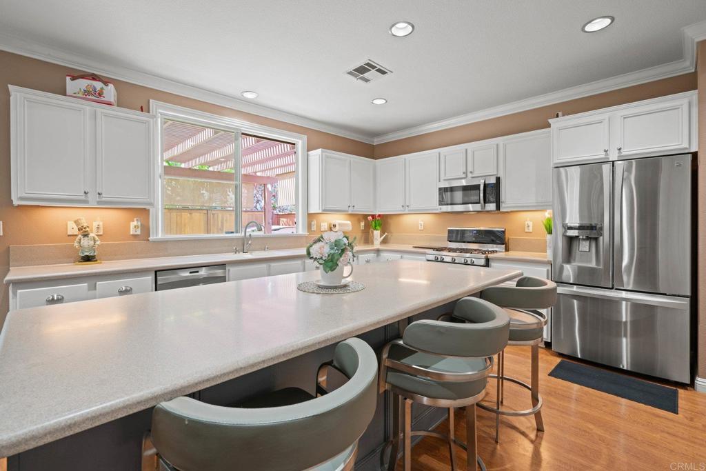 5191 Cobalt Way Oceanside, CA 92057 - Photo 23 of 61 a kitchen with stainless steel appliances a sink a stove a refrigerator and cabinets