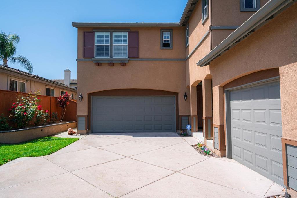 5191 Cobalt Way Oceanside, CA 92057 - Photo 4 of 61 a front view of a house with a yard and garage