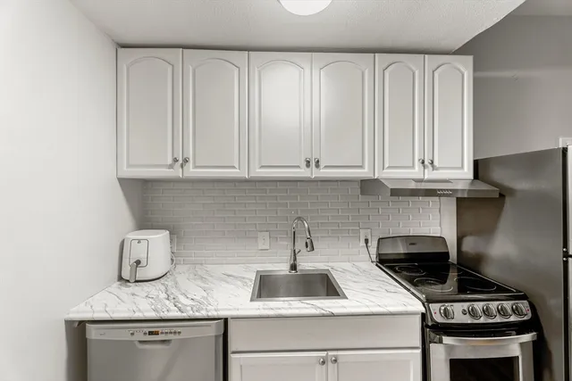a kitchen with stainless steel appliances granite countertop a sink stove and cabinets