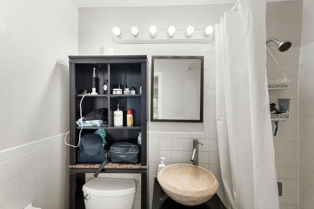 a bathroom with a toilet a sink and mirror