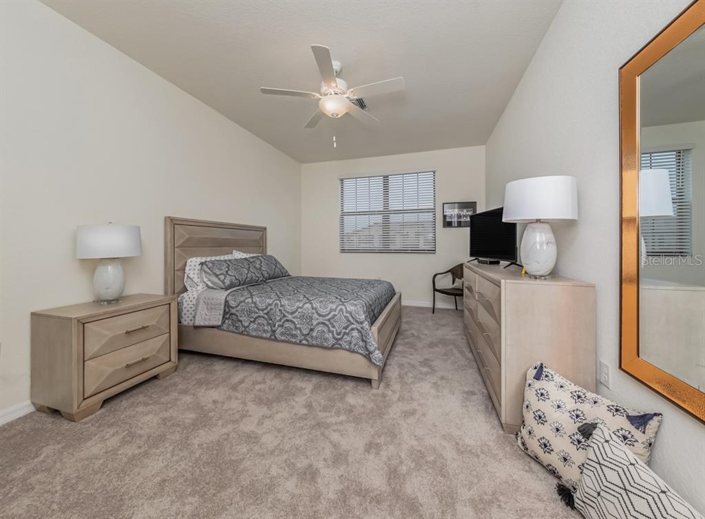 12550 Ghiberti Circle, Unit 201 Venice, FL 34293 - Photo 18 of 44 a spacious bedroom with a bed and a window