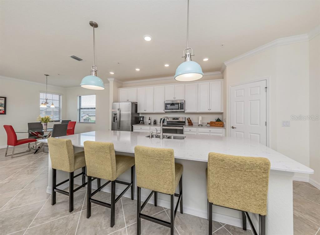 12550 Ghiberti Circle, Unit 201 Venice, FL 34293 - Photo 8 of 44 a large kitchen with a table and chairs