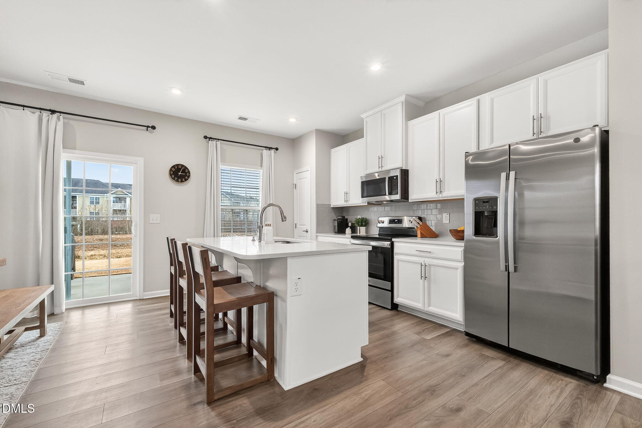 4922 Crossley Street Raleigh, NC 27616 - Photo 8 of 28 a kitchen with a refrigerator a microwave oven a sink dishwasher with a dining table and chairs