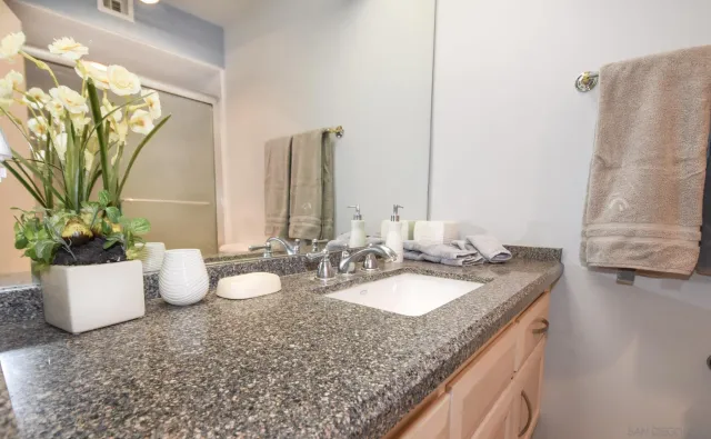 a bathroom with a granite countertop sink and a mirror