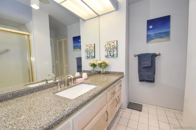 a bathroom with a granite countertop sink and a mirror