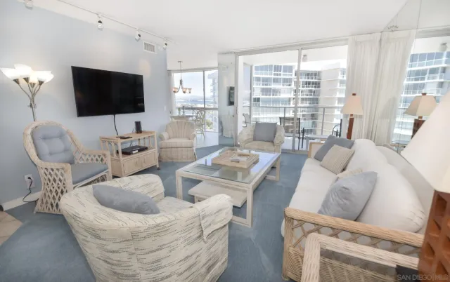 a living room with furniture a flat screen tv and a floor to ceiling window