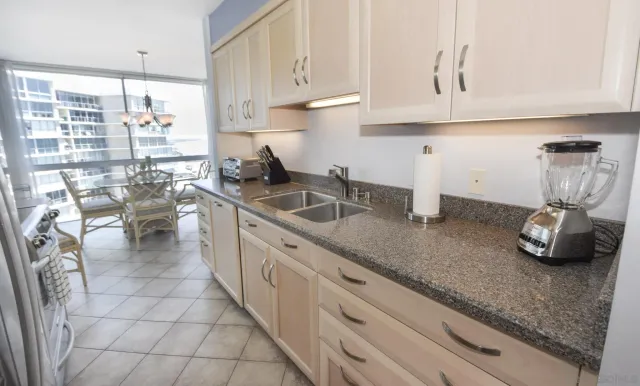 a kitchen with stainless steel appliances granite countertop a sink dishwasher and cabinets with wooden floor