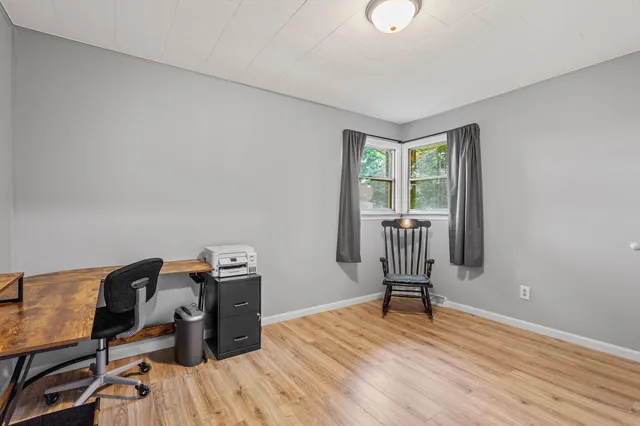 a view of a workspace with furniture and a window