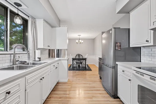 a large white kitchen with a sink and refrigerator