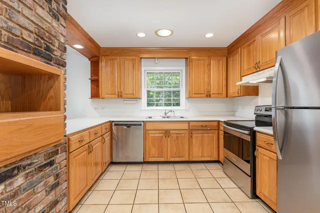 a kitchen with stainless steel appliances granite countertop a refrigerator and a stove top oven