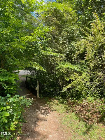an aerial view of a house with a yard and large trees