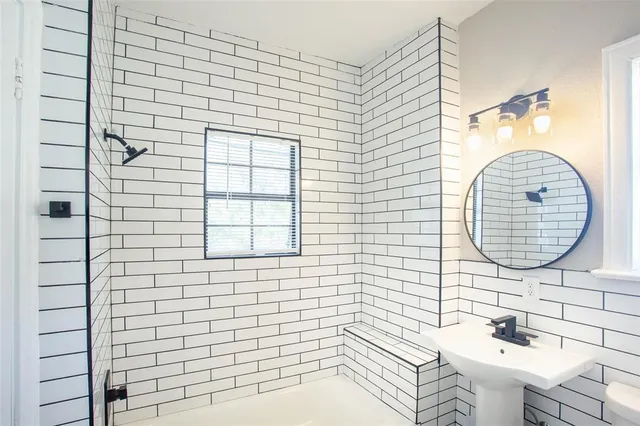 a bathroom with a sink a mirror and a shower