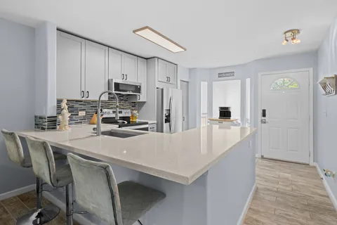 a kitchen with kitchen island a appliances dining table and chairs