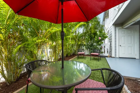 a backyard with table and chairs under an umbrella