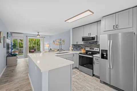 a kitchen with refrigerator a stove a sink and a window