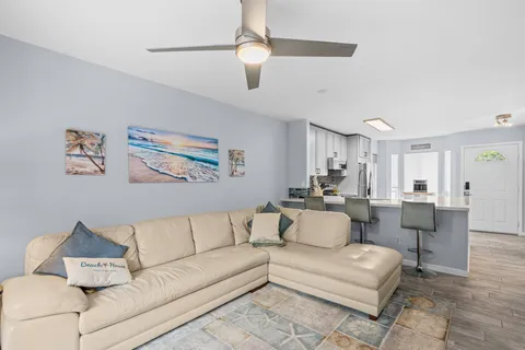 a living room with furniture and a ceiling fan