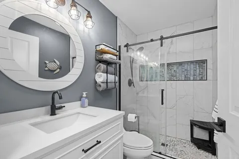 a bathroom with a sink a toilet and shower