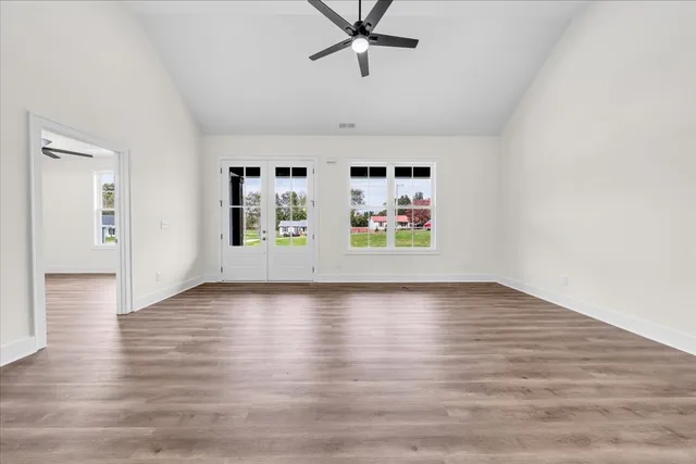 a view of a livingroom with wooden floor and a ceiling fan