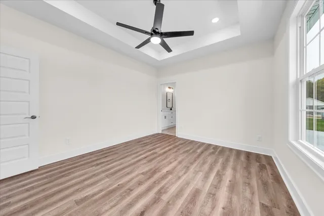 an empty room with a window and a ceiling fan